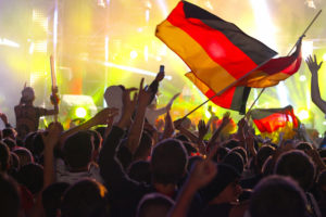 Berlin, Germany - July 13, 2014: Germany wins FIFA World Cup 2014, crowd of people gathering at Brandeburger Tor in Berlin for partying, getting crazy and supporting their team. A night of joy and happiness, with flags, music, lights and ecstatic crowd.